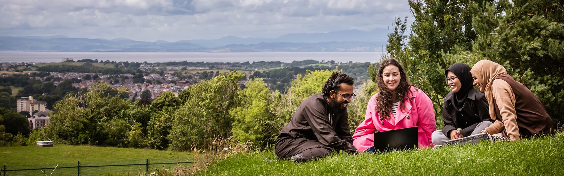 Students in a field overlooking Lancaster and the Lake District