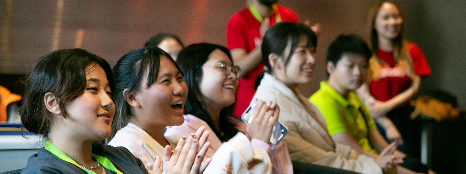 Global Summer School students in the audience clapping during 2023 social event