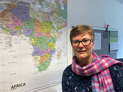 Charlotte standing next to a wall map of Africa.