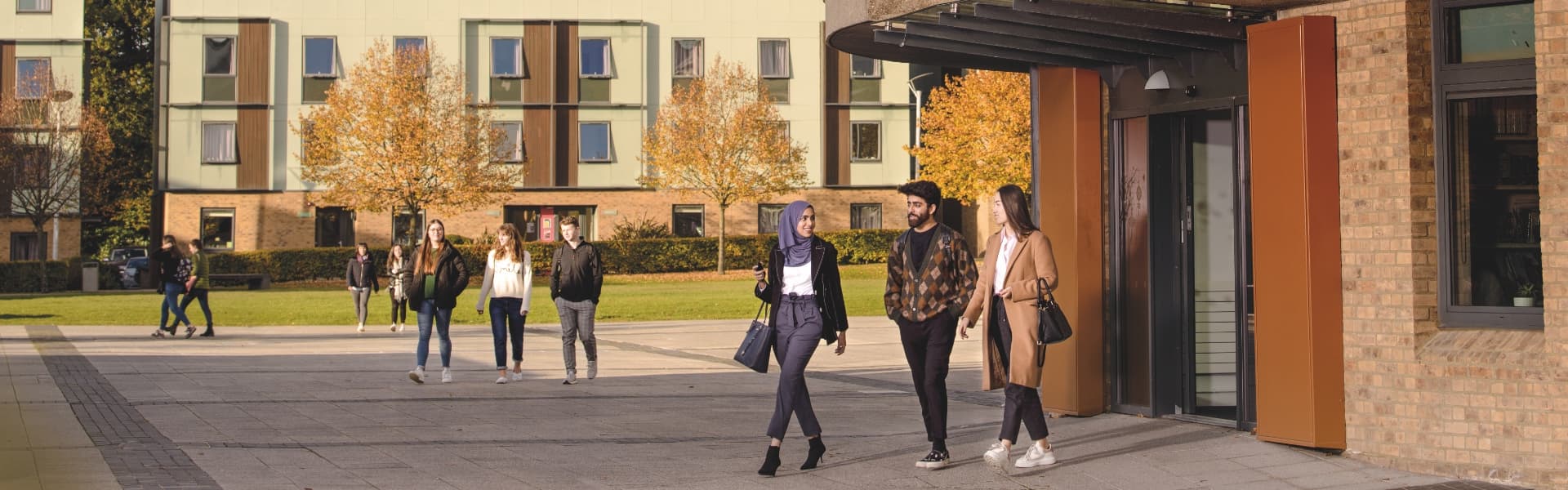 A group of students walk in the square outside the Confucius Centre.