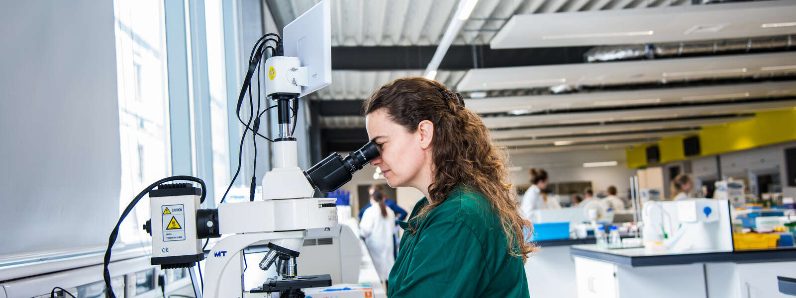 Researcher looking down a microscope