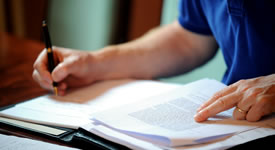 a picture of someone writing in a book