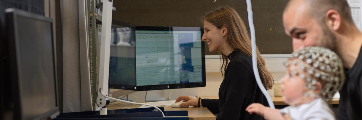 A researcher conducting an experiment with a father and his baby.