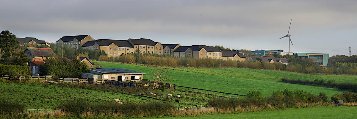 The Lancaster campus and fields with the wind turbine in the background.
