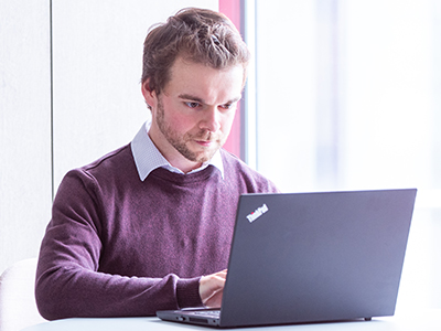 Male working at a table on a laptop
