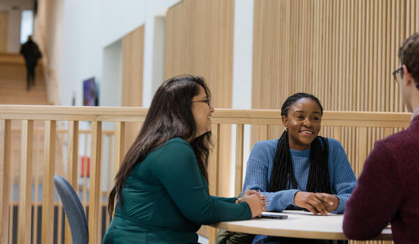 Three students sitting at a table talking