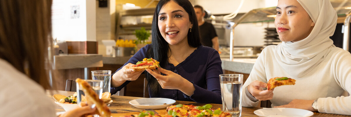 Two students eating pizza