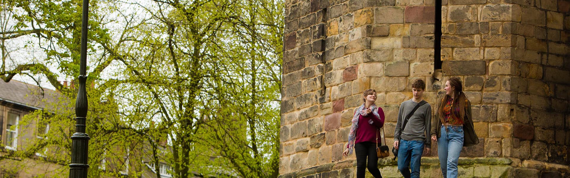 Lancaster University students studying on campus outside in the sunshine