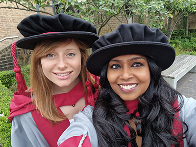 Lauren and Sangeetha pose for the camera during their graduation ceremony