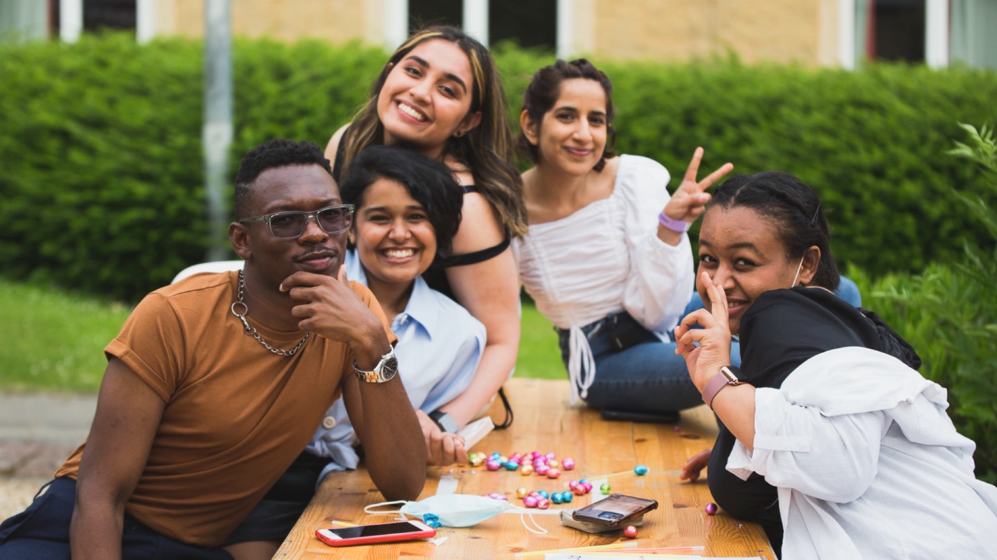 Students on a bench outside accommodation buildings