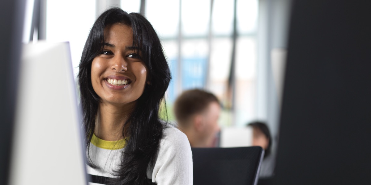 A student in Computing sits in front of a computer