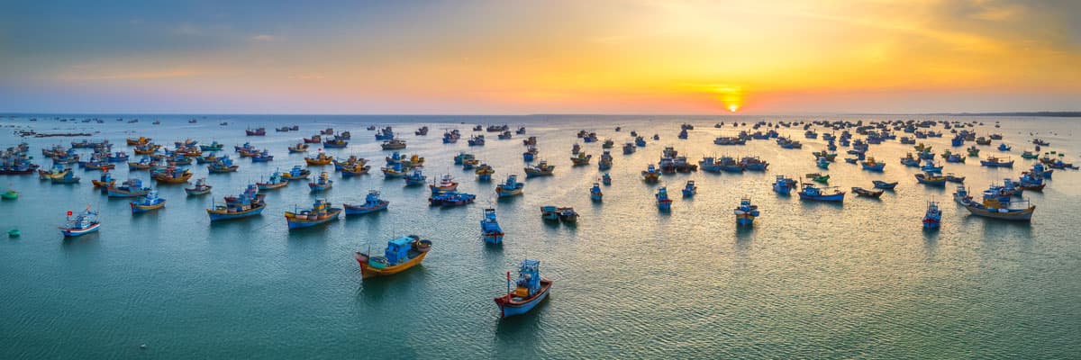 Mui Ne fishing village in sunset sky with hundreds of boats anchored