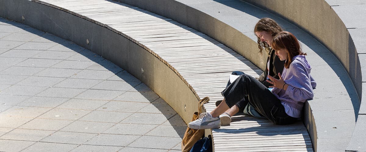 two students sitting and reading on some outdoor steps