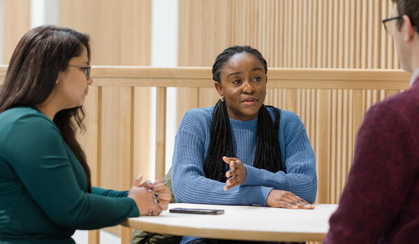 Students around a table looking at a laptop