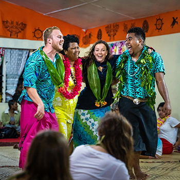 Two students celebrating the end of the ThinkPacific project in Fiji with project leaders. 