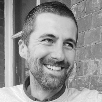 A black and white image of a man with short dark hair